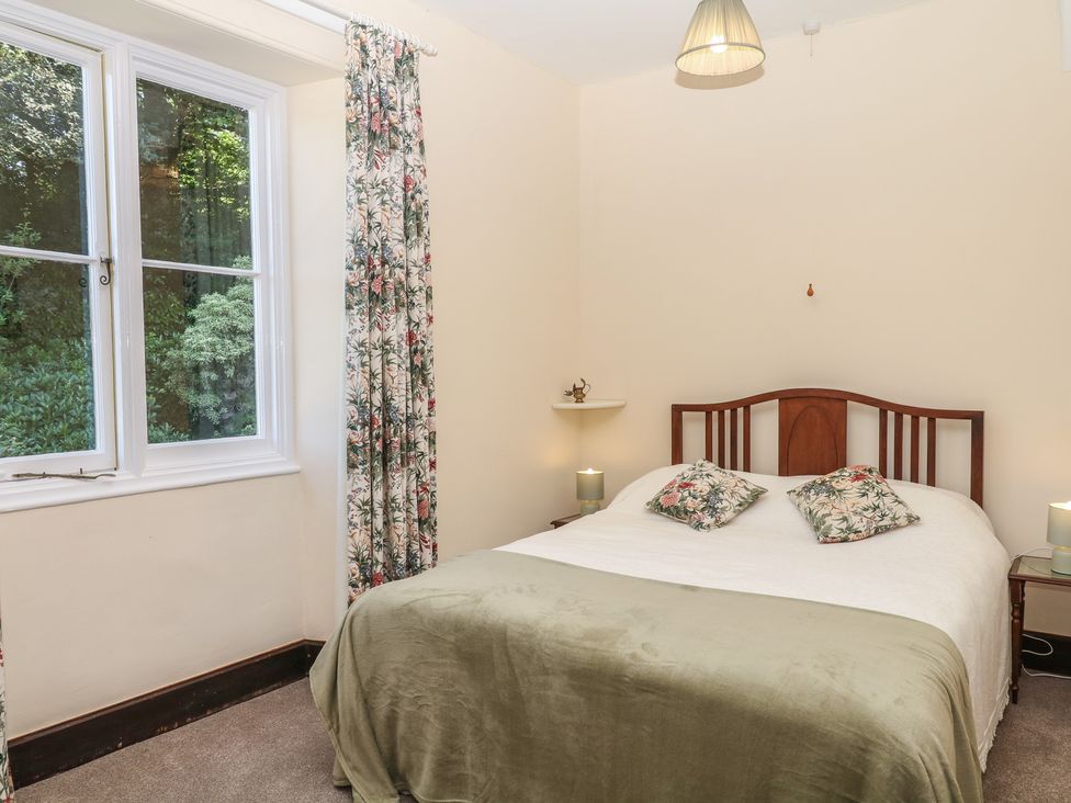 A bedroom with a bed and window at Lukesland Wing in Ivybridge