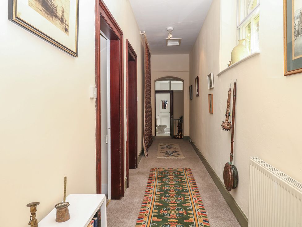A hallway with doors and paintings at Lukesland Wing in Ivybridge