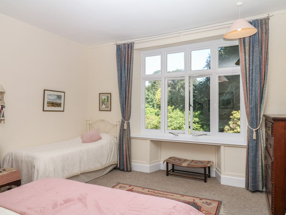 A bedroom with two beds and a window at Lukesland Wing Ivybridge