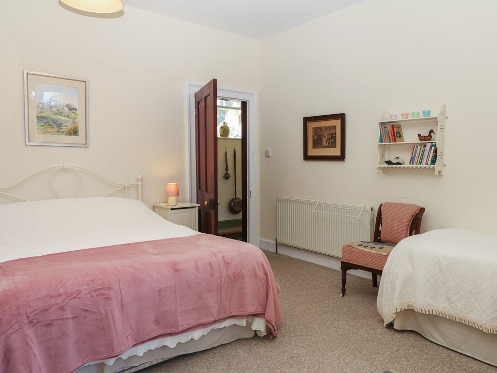 A bedroom with a bed and a chair at Lukesland Wing in Ivybridge