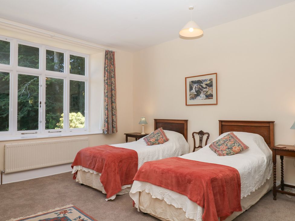 A bedroom with two beds and a window at Lukesland Wing in Ivybridge