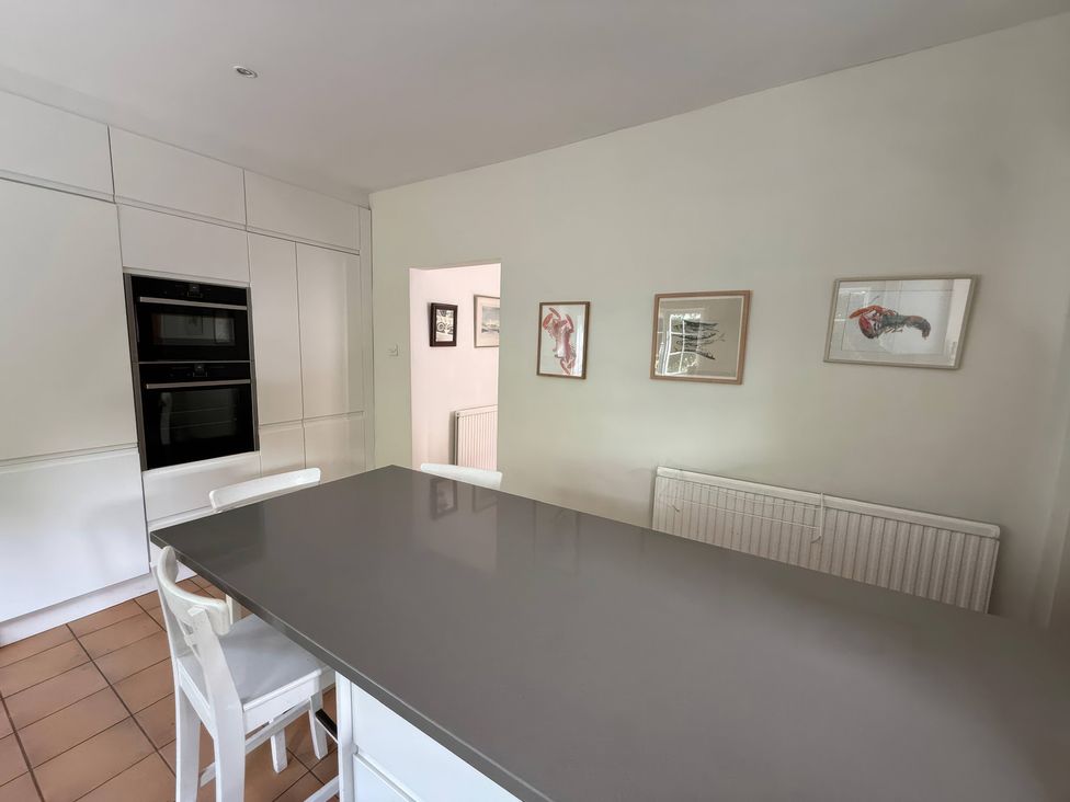 A kitchen with a kitchen island and oven at Avenue Road in Lymington
