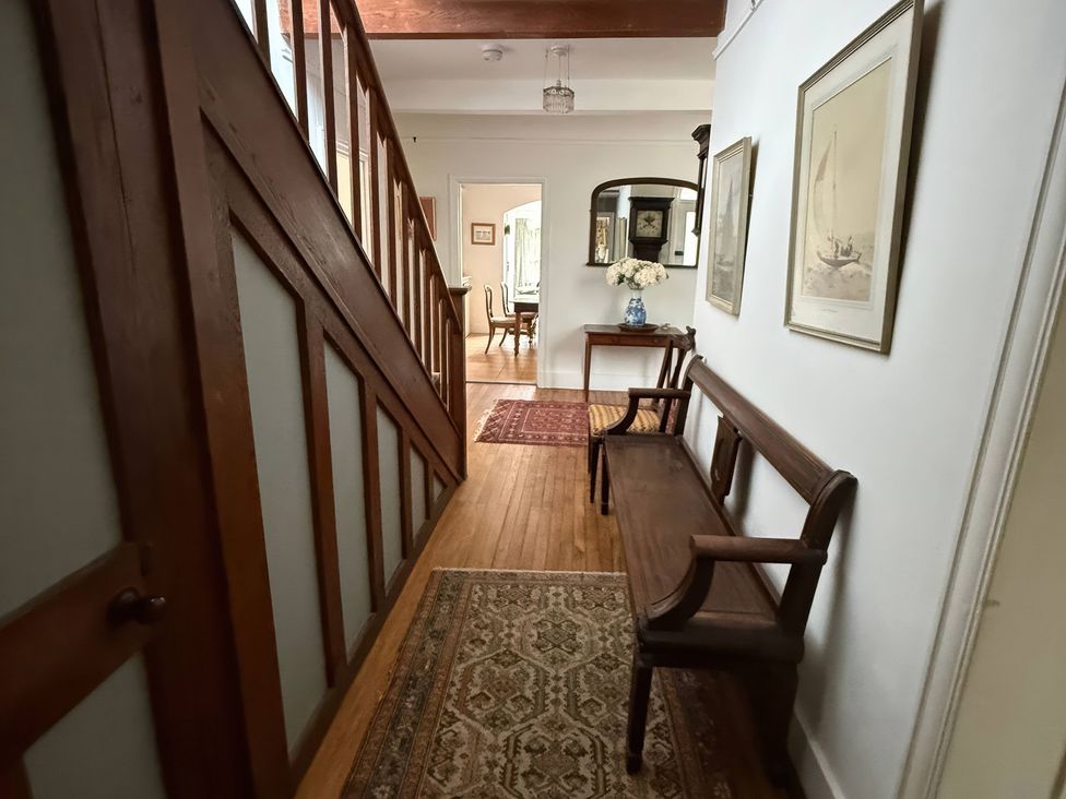 A hallway with a staircase and a bench at Avenue Road in Lymington