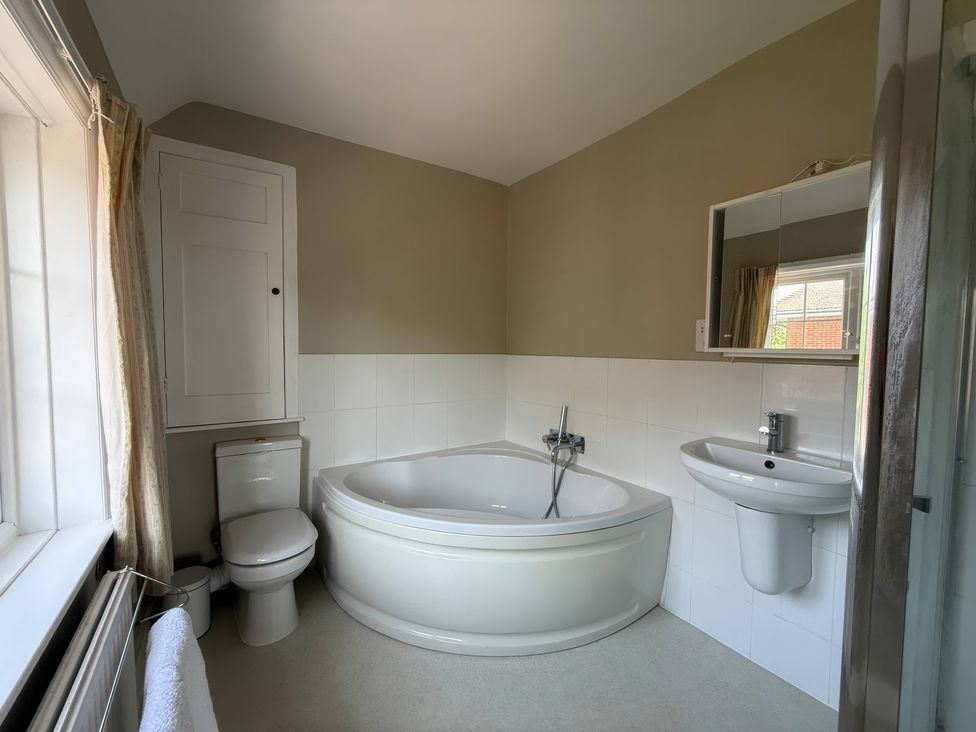 A bathroom with a bathtub, toilet, and sink at Avenue Road in Lymington