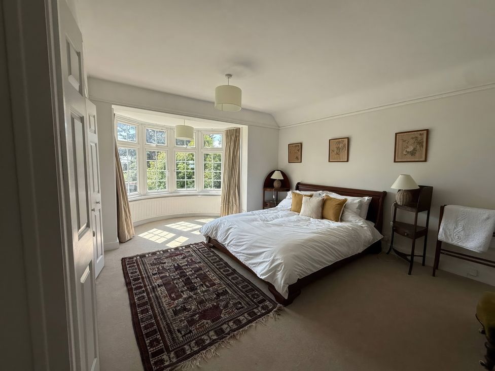 A bedroom with a bed and windows at Avenue Road in Lymington