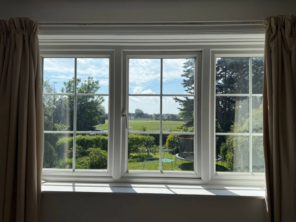 A window view of a garden with trees at Avenue Road in Lymington