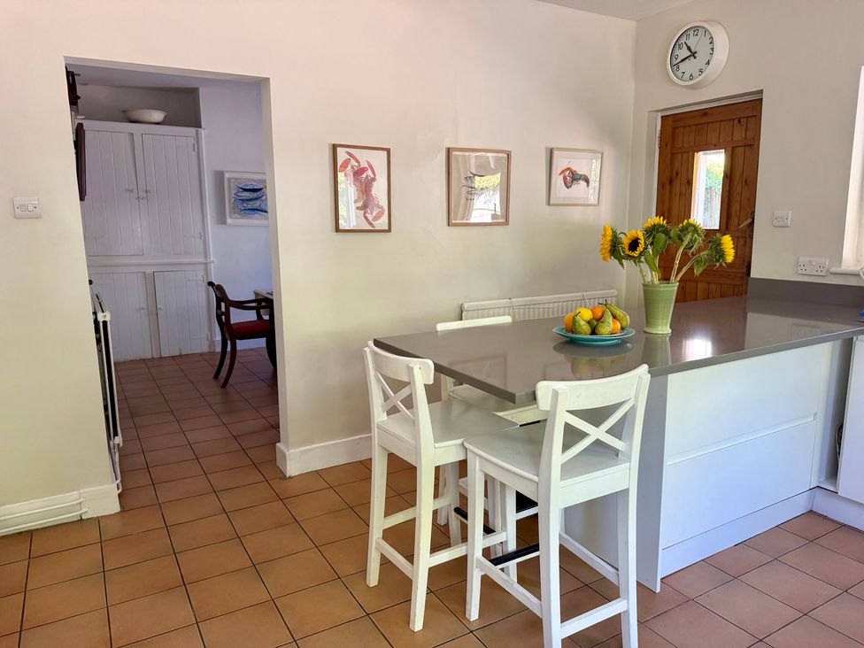 A kitchen with bar stools and a fruit bowl at Avenue Road in Lymington