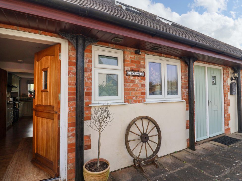 An entrance with a wooden door and a sign at The Coach House in Dorchester