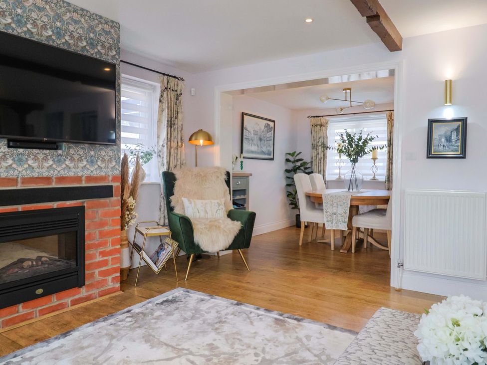 A living room with a fireplace and dining area at The Coach House in Dorchester