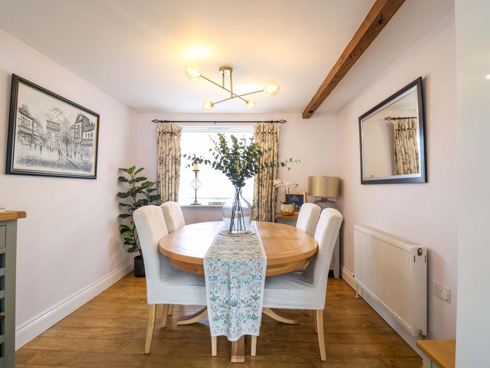 A dining room with a round table and chairs at The Coach House in Dorchester