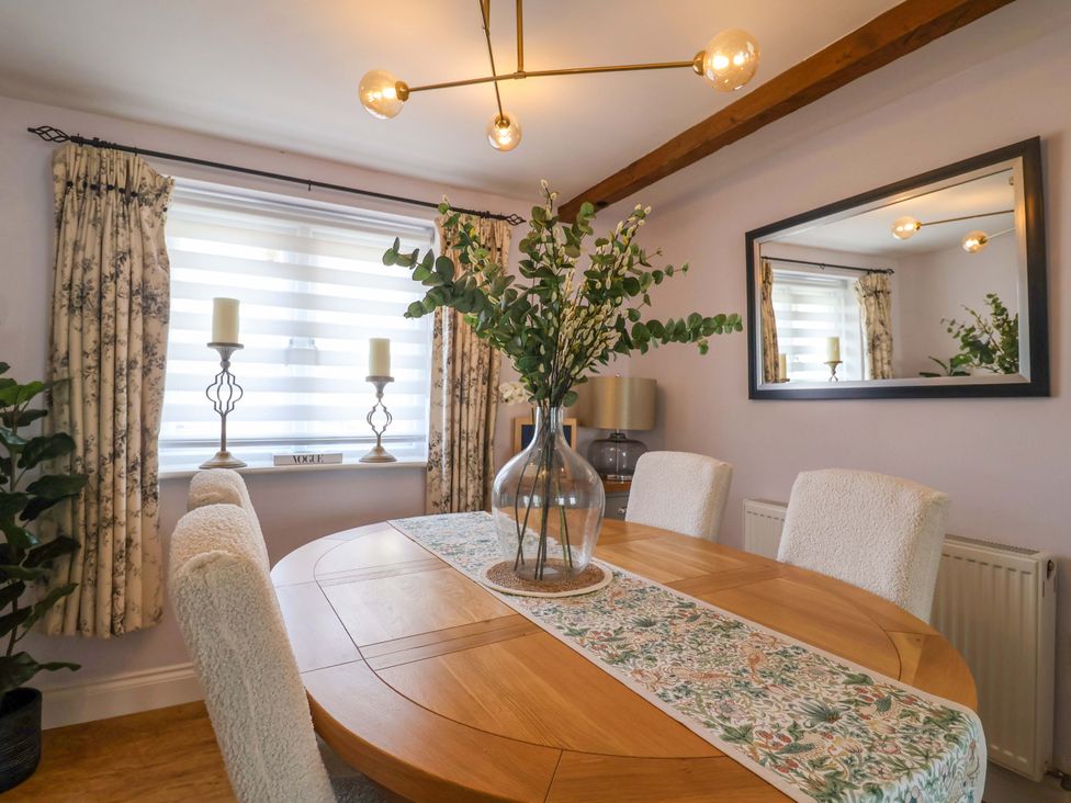 A dining room with a table and chairs at The Coach House in Dorchester