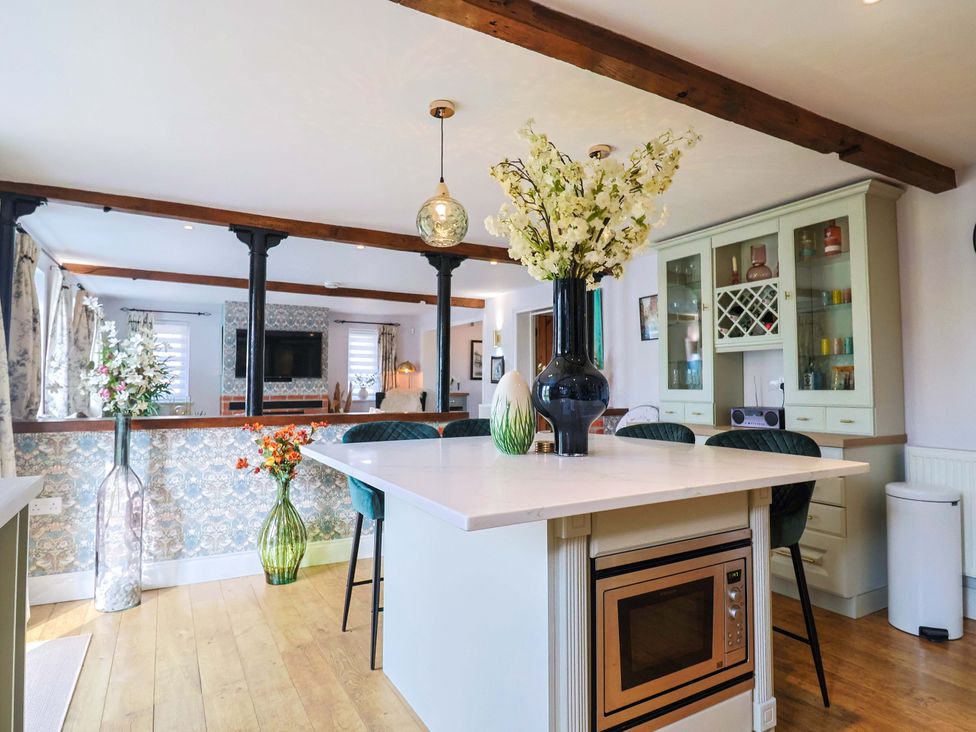 A kitchen with flowers on a table at The Coach House Dorchester