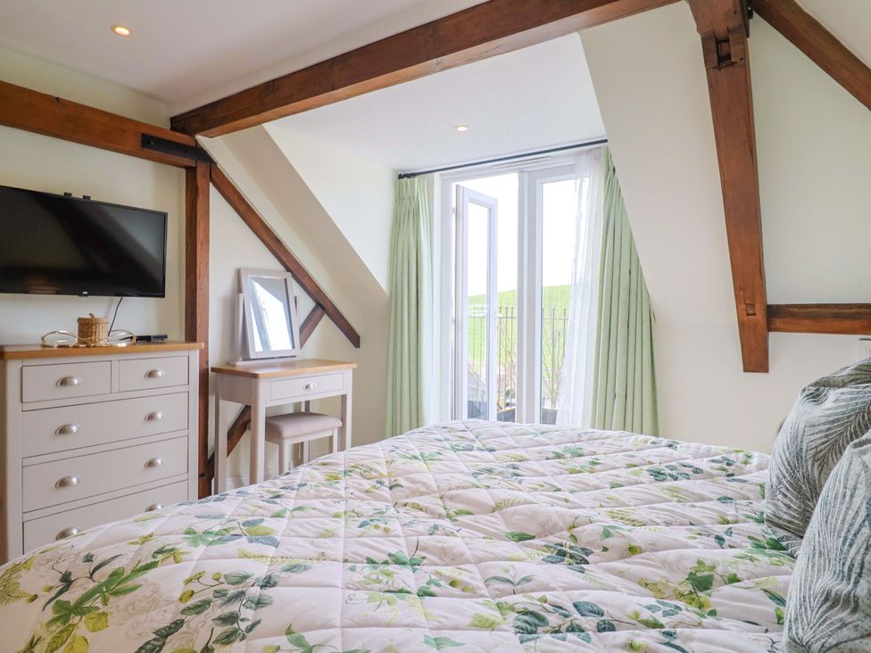 A bedroom with a bed and television at The Coach House in Dorchester