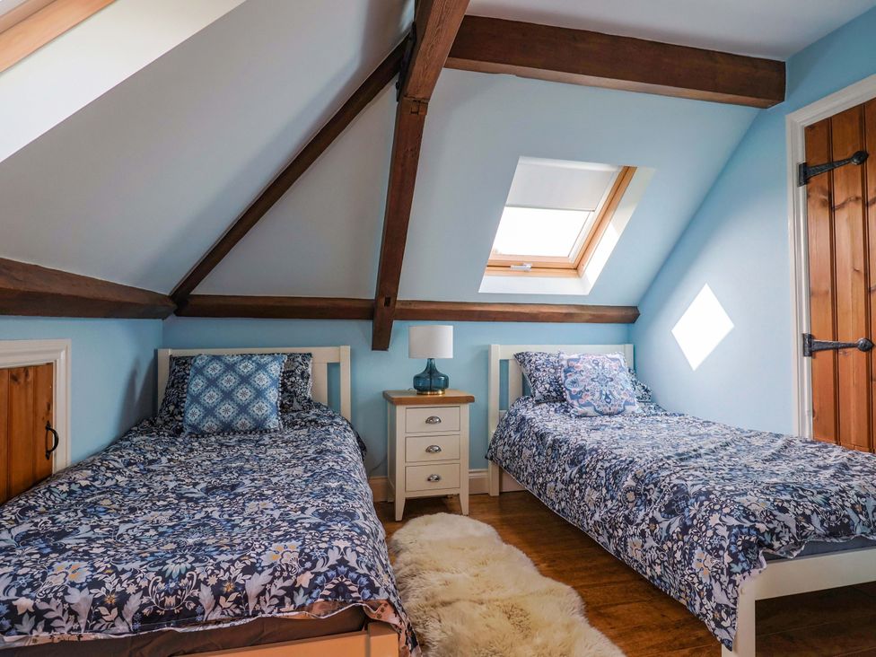 A bedroom with two single beds and a bedside table at The Coach House in Dorchester