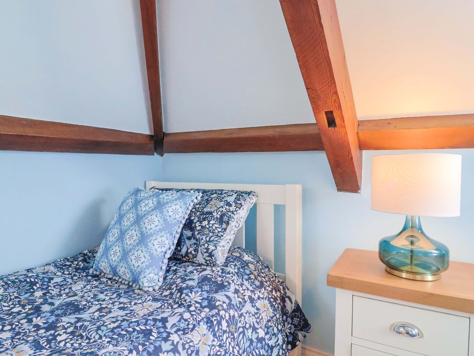 A bedroom with a bed and bedside table at The Coach House in Dorchester