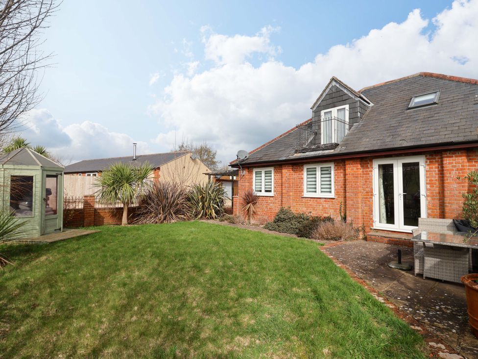 A garden with grass and a sitting area at The Coach House in Dorchester
