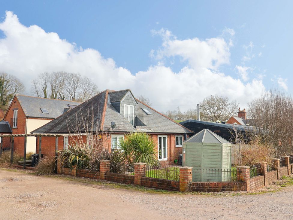 An outdoor view of a house with a shed and garden at The Coach House in Dorchester