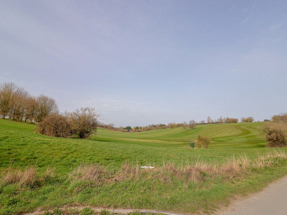 A view of a golf course with hills and trees at The Coach House Dorchester