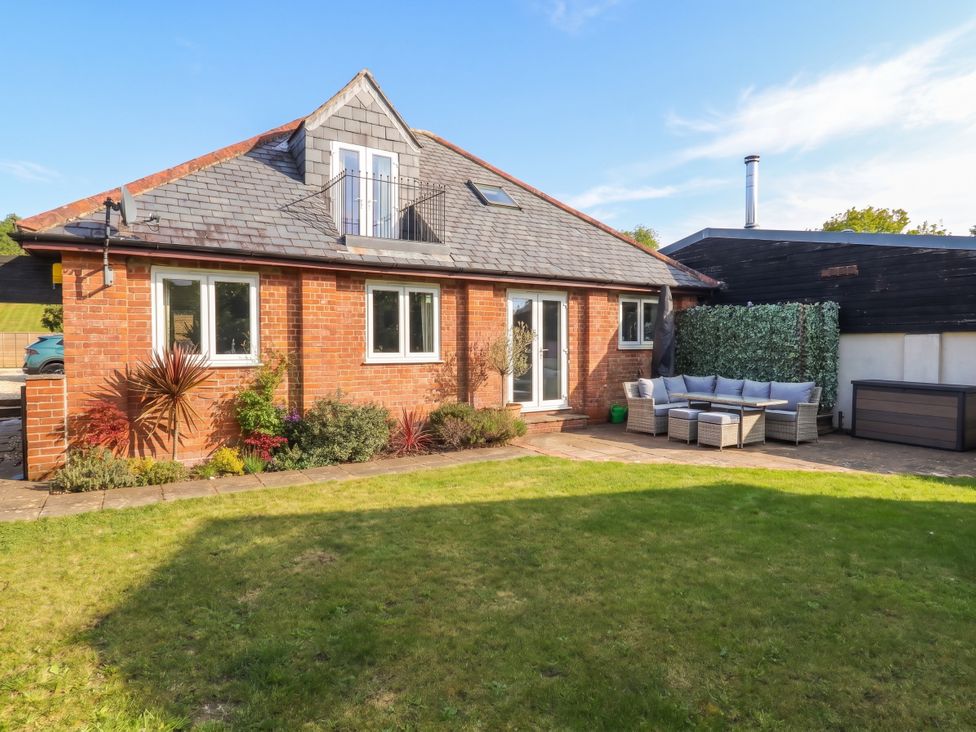 A house with a garden and patio furniture at The Coach House near Charminster