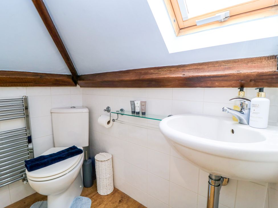A bathroom with a toilet and sink at The Coach House Near Charminster