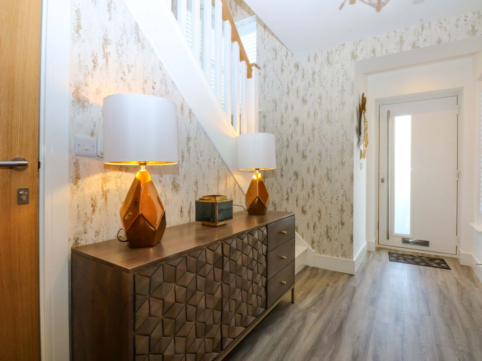 A hallway with lamps and a table at 2 Glan Yr Aber in Colwyn Bay