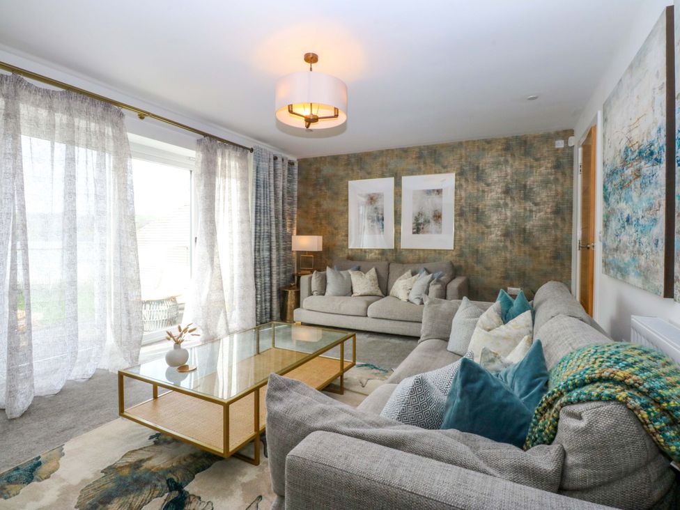 A living room with a glass table and sofas at 2 Glan Yr Aber in Colwyn Bay