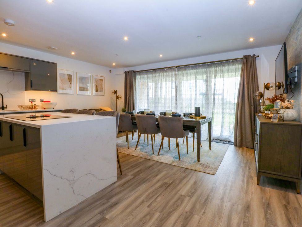 A dining room with a kitchen island and dining table at 2 Glan Yr Aber in Colwyn Bay