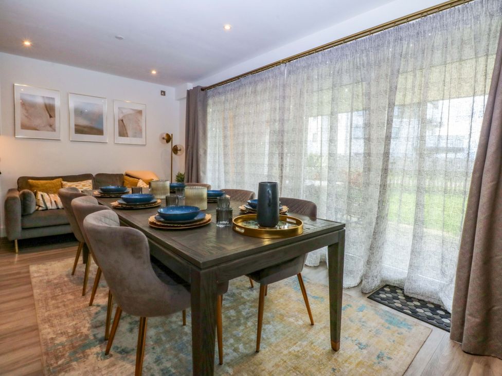 A dining room with a table set for a meal at 2 Glan Yr Aber in Colwyn Bay