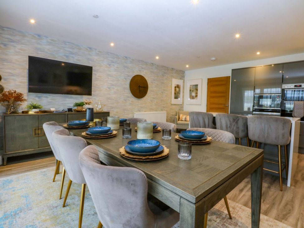 A dining room with a table and chairs at 2 Glan Yr Aber in Colwyn Bay