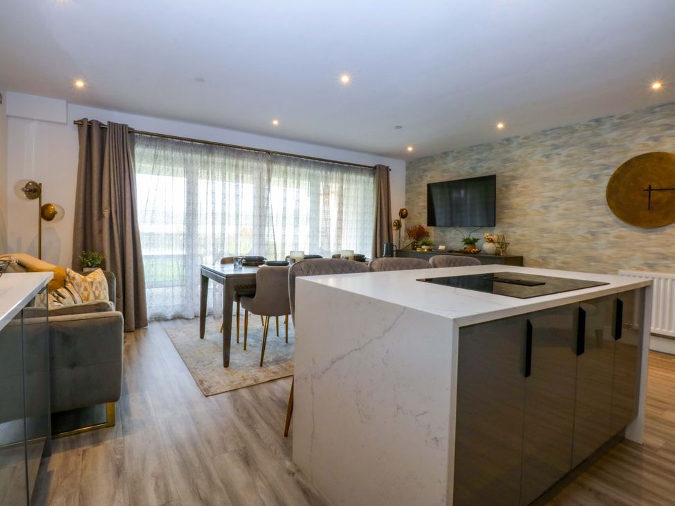 A dining room with a kitchen island and table at 2 Glan Yr Aber Colwyn Bay