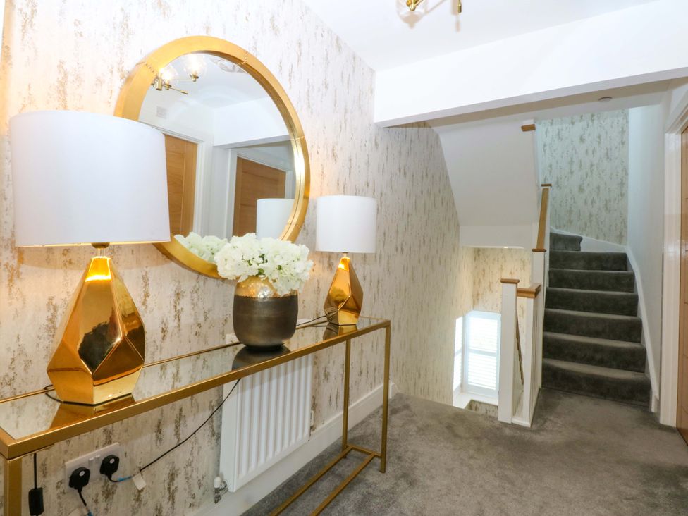 A hallway with a console table, lamps and mirror at 2 Glan Yr Aber, Colwyn Bay
