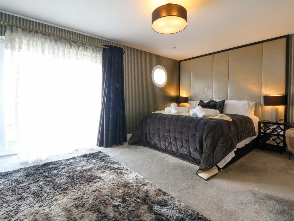 A bedroom with a bed and window at 2 Glan Yr Aber in Colwyn Bay