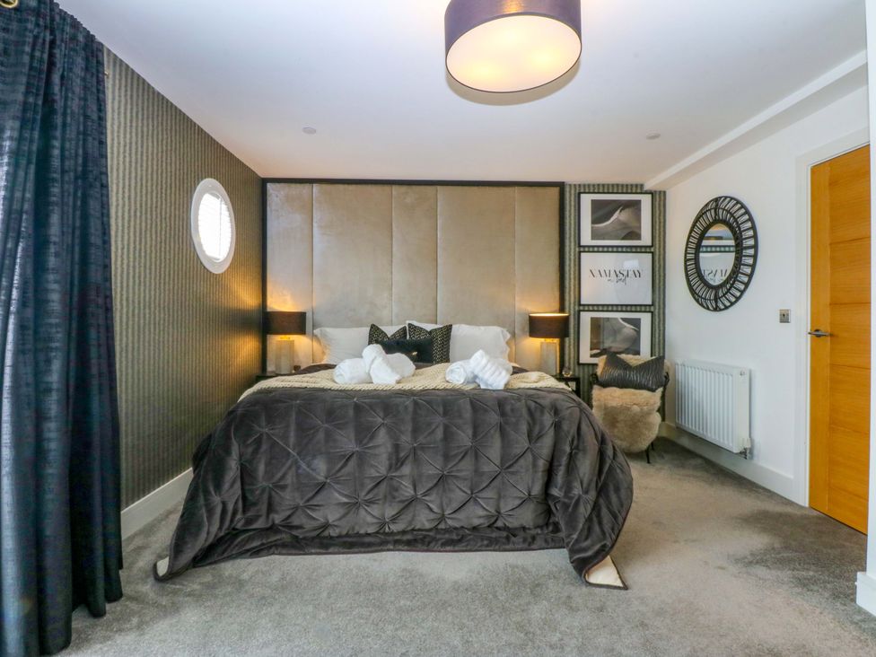 A bedroom with a bed and bedside table at 2 Glan Yr Aber in Colwyn Bay