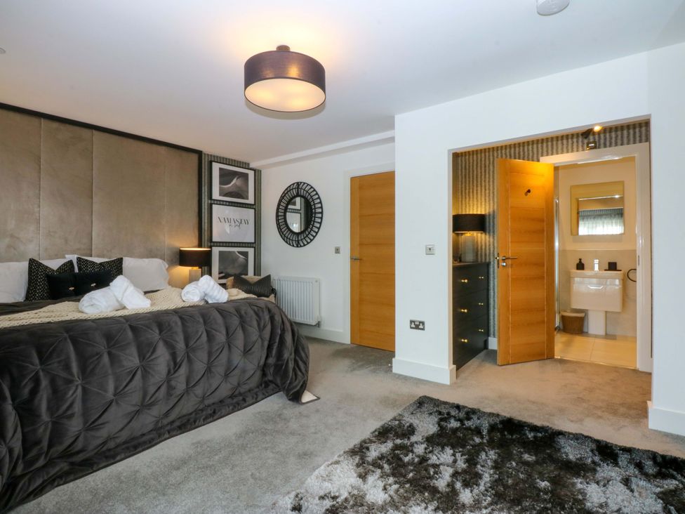 A bedroom with a bed and an ensuite bathroom at 2 Glan Yr Aber in Colwyn Bay