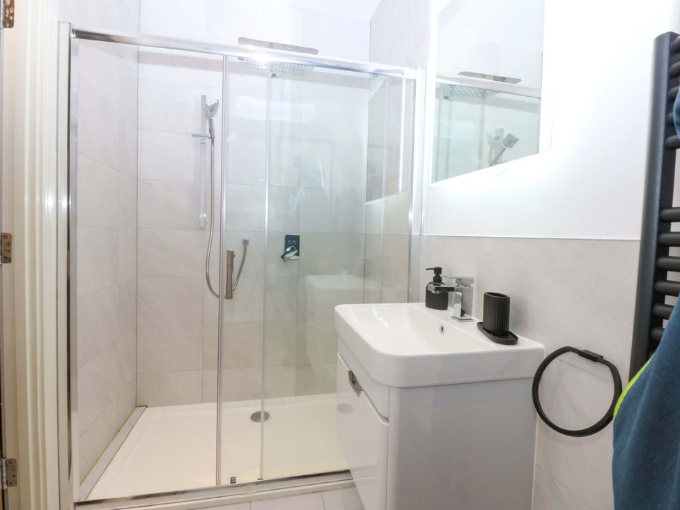 A bathroom with a shower, toilet, and sink at 2 Glan Yr Aber, Colwyn Bay