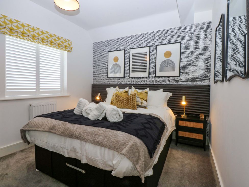 A bedroom with a bed and wall art at 2 Glan Yr Aber in Colwyn Bay