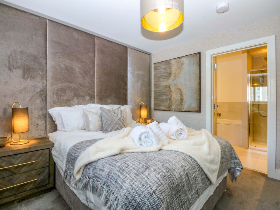 A bedroom with a bed and bedside table at 2 Glan Yr Aber in Colwyn Bay