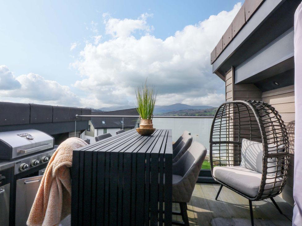An outdoor terrace with a grill and seating at 2 Glan Yr Aber in Colwyn Bay
