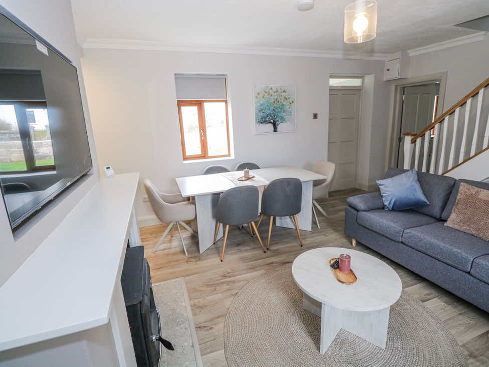 A living room with a sofa and dining area at Ballina in Inverin