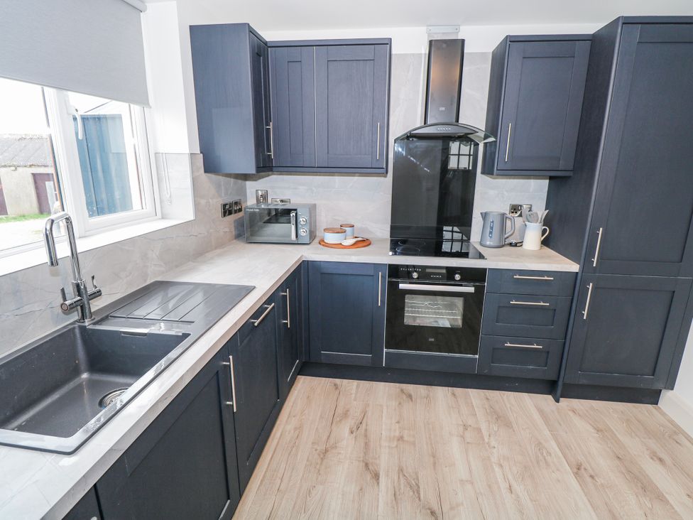 A kitchen with dark cabinets and appliances at Ballina in Inverin