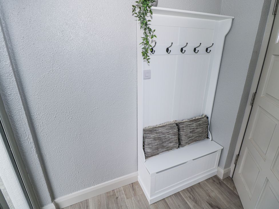 An entryway with a bench and hooks for coats at Ballina in Inverin