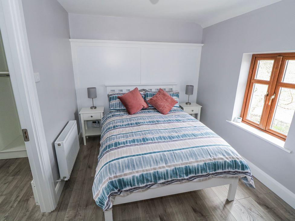A bedroom with a bed and bedside tables at Ballina in Inverin