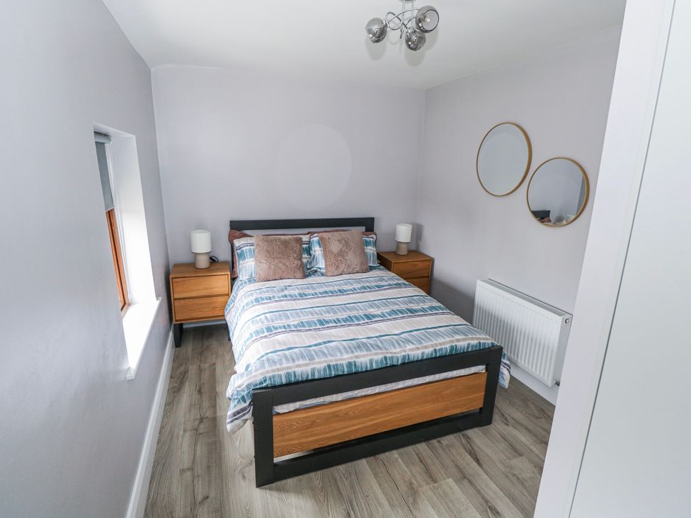 A bedroom with a bed and nightstands at Ballina in Inverin
