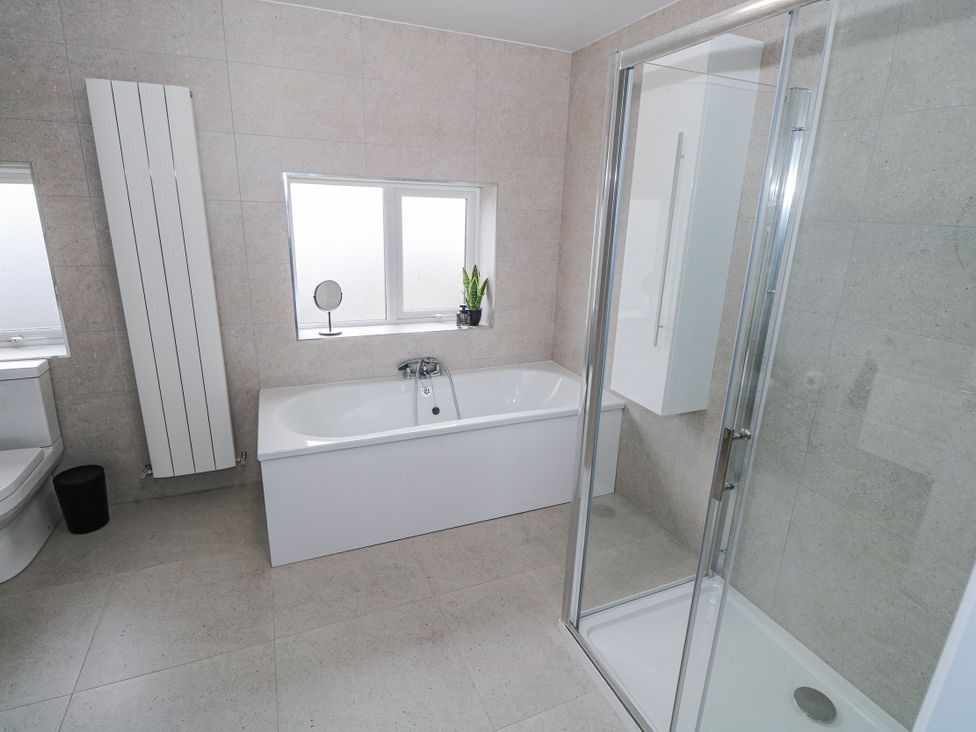 A bathroom with a bathtub, shower, and sink at Ballina in Inverin