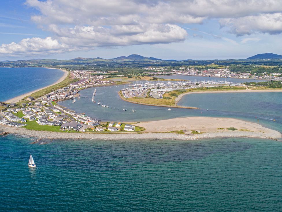 An aerial view of a coastal area with beach and marina at Ty Pen in Nefyn