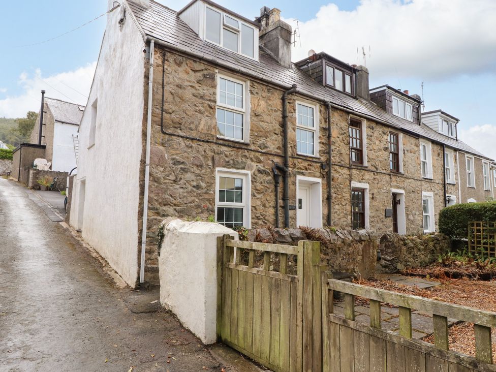 A stone house with windows and a gate at Ty Pen in Nefyn