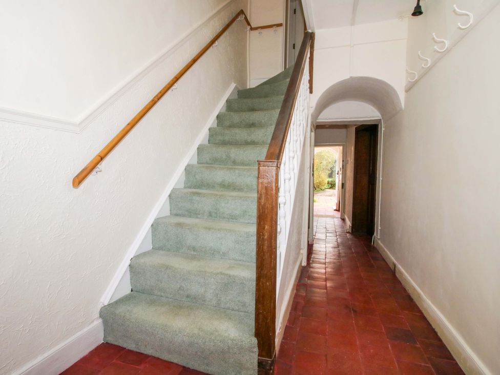 A hallway with stairs and a doorway at The Apartment at the Grey House in Albrighton
