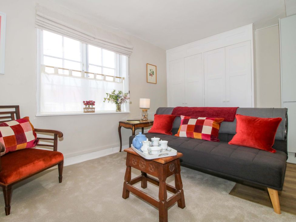 A living room with a sofa and tea set at The Apartment at the Grey House in Albrighton