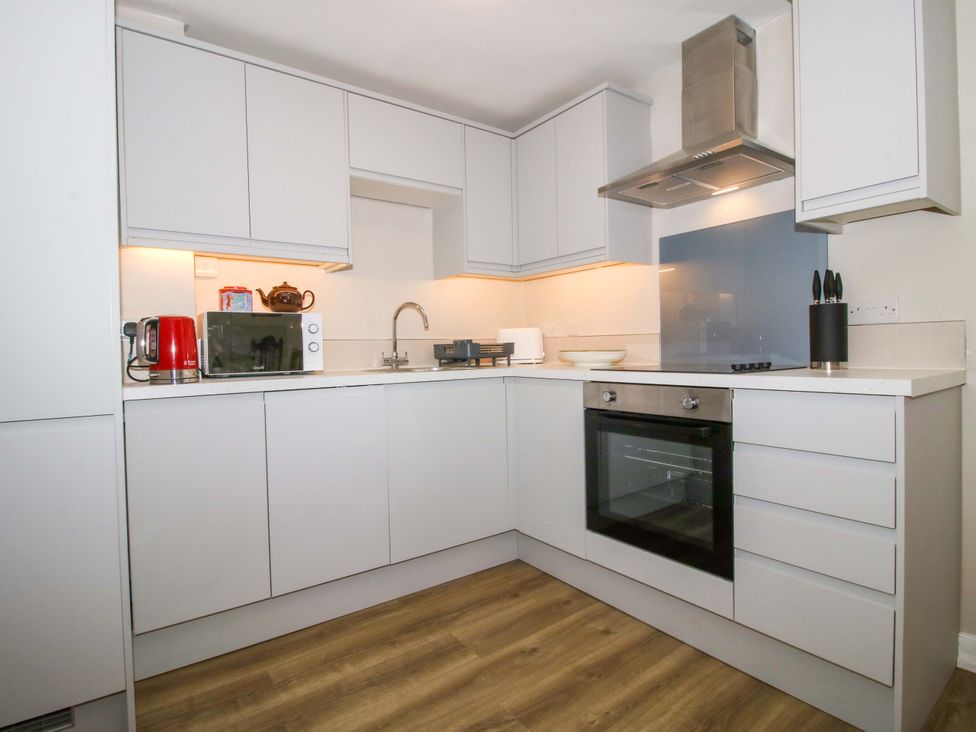 A kitchen with cabinets, oven, microwave, and kettle at The Apartment at the Grey House Albrighton