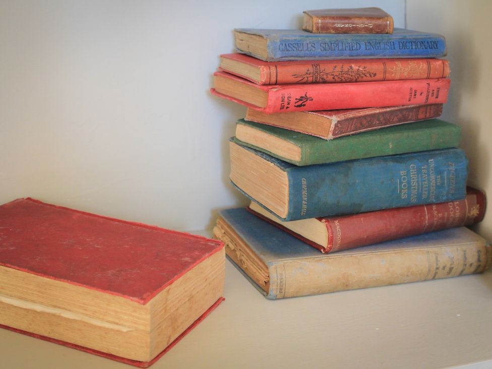 A stack of books on a shelf at Stanbridge Cottage in Malmesbury